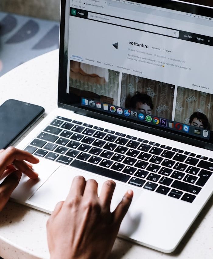 Person typing on laptop at a café table, ideal for tech and freelance themes.
